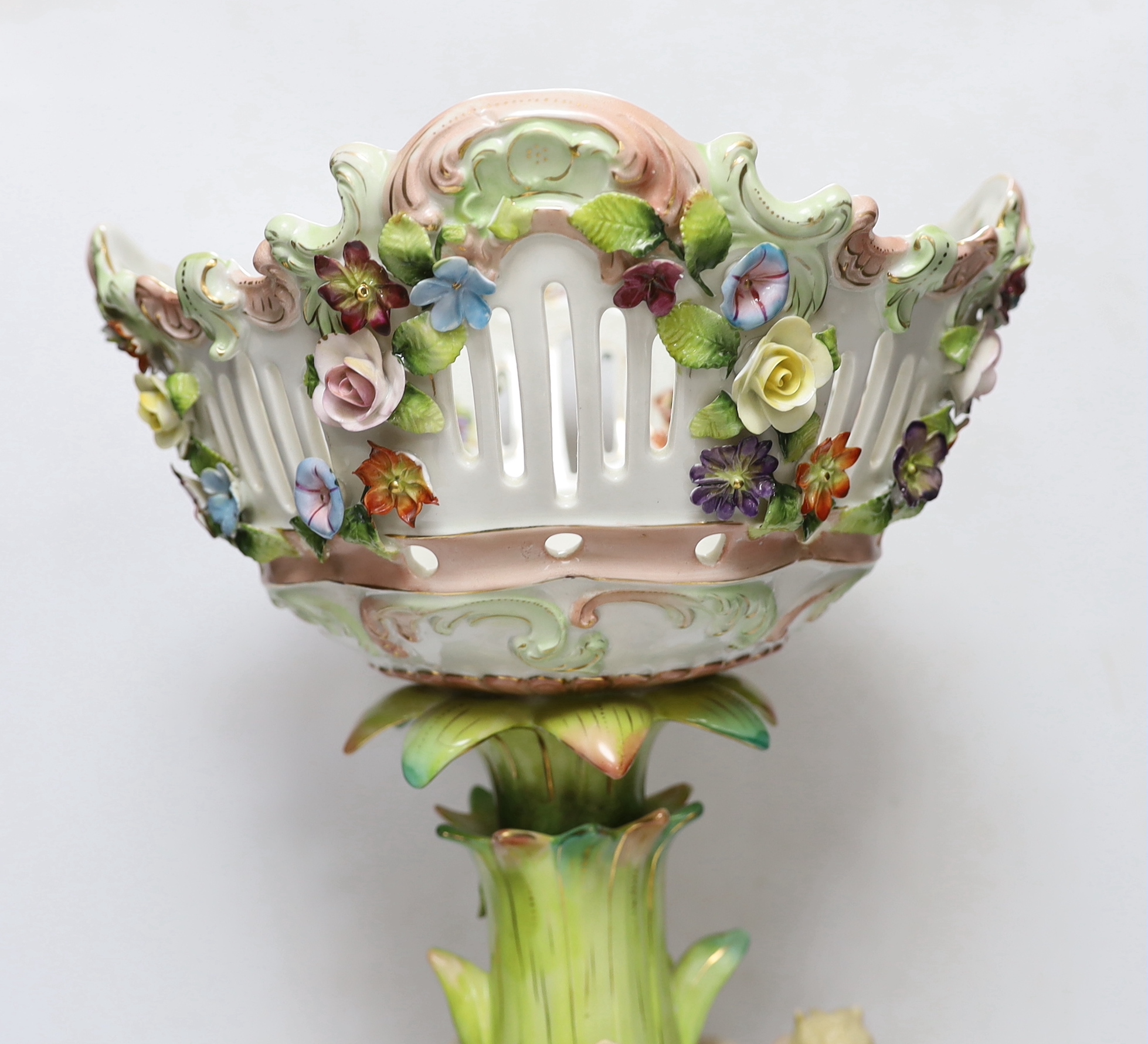 A Sitzendorf figural centrepiece, a smaller similar centrepiece and an English porcelain basket, tallest 54cm